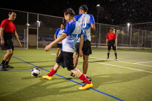 istock Rainy Night Soccer Game Featuring Diverse Players 2200056508