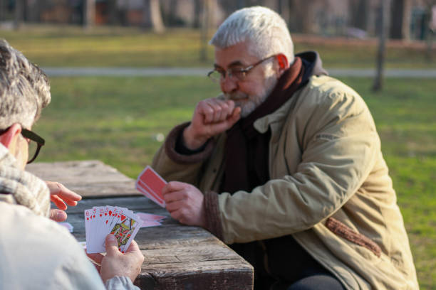 istock Pensioners playing card in public park 2200056533