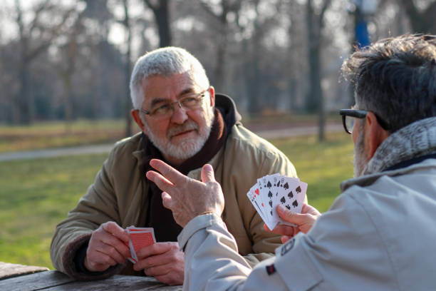 istock Pensioners playing card in public park 2200056534