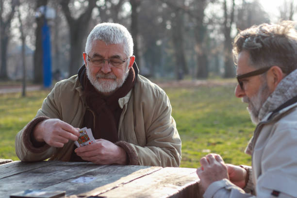 istock Pensioners playing card in public park 2200056557