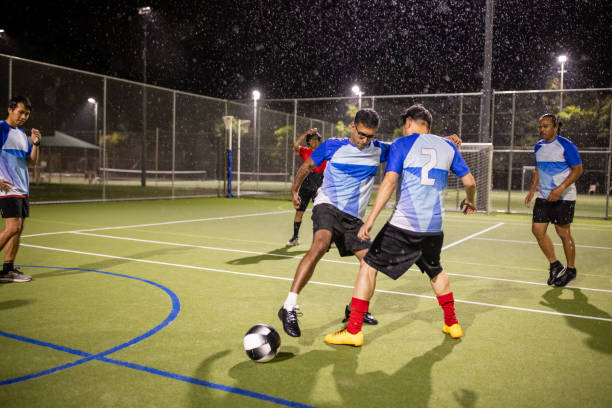 istock Rainy Night Soccer Game Featuring Diverse Players 2200056560