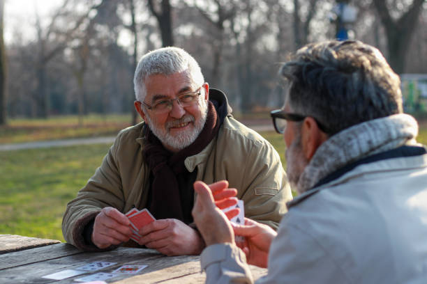 istock Pensioners playing card in public park 2200056573