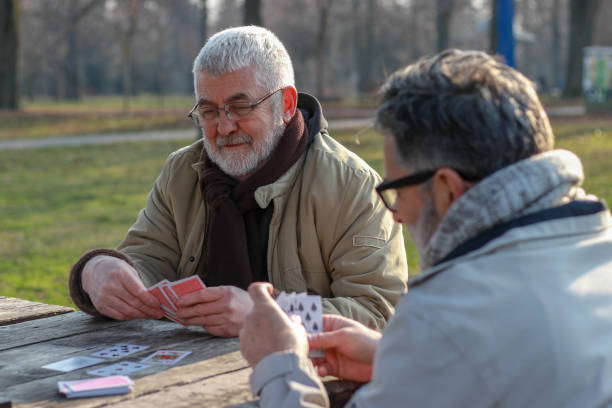 istock Pensioners playing card in public park 2200056578