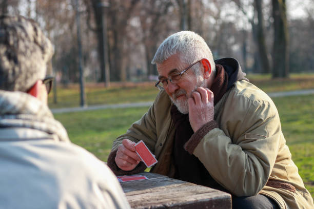 istock Pensioners playing card in public park 2200056596