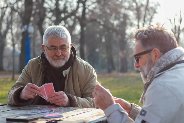 istock Pensioners playing card in public park 2200056630