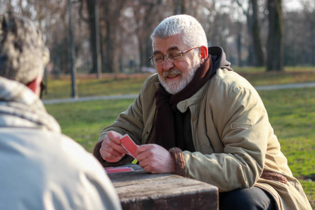 istock Pensioners playing card in public park 2200056633