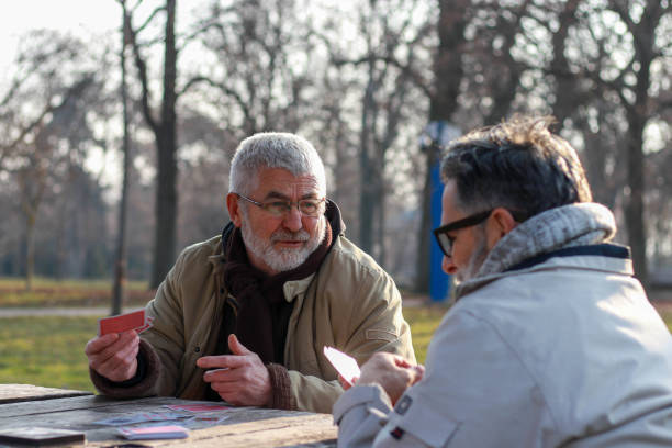 istock Pensioners playing card in public park 2200056637