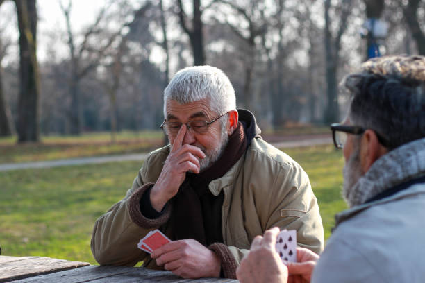 istock Pensioners playing card in public park 2200056659