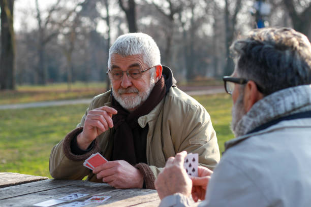 istock Pensioners playing card in public park 2200056660