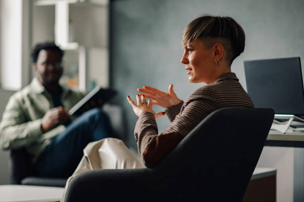 istock Businesswoman gesturing while talking to a colleague in office 2200058662