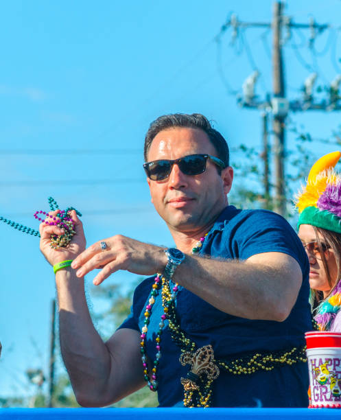 Mobile, Alabama, USA - March 2, 2014: A man throws Mardi Gras beads to the crowd during the Joe Cain Day parade in Mobile, Alabama.