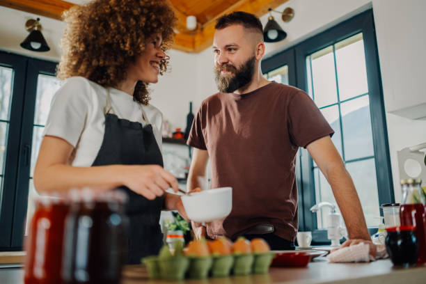 istock Couple cooking together, mixing ingredients in the kitchen 2200061741