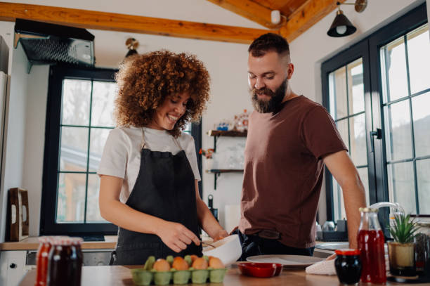 istock Happy couple preparing food together in modern kitchen 2200061851