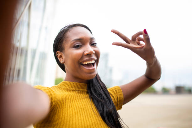 istock Woman taking selfie with peace hand sign 2200065326