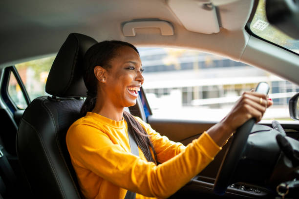 Portrait of joyful young african american woman driving a car