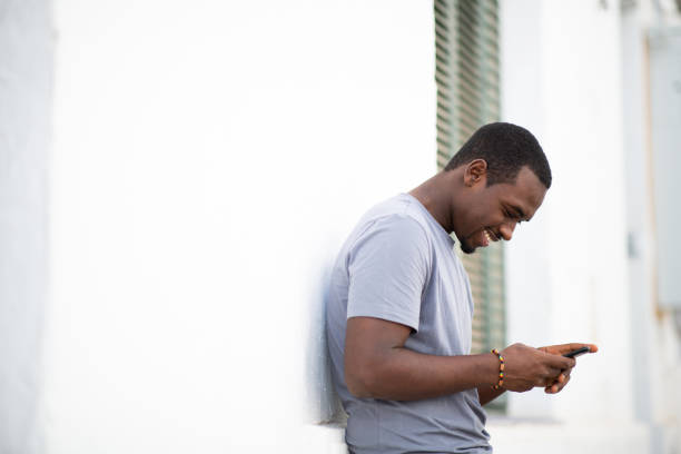 istock Handsome young african man looking at mobile phone 2200065644