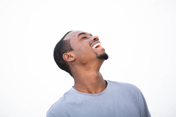 Side portrait of cheerful young african american man laughing against white background