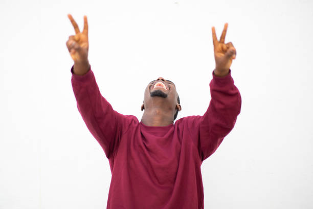 istock Cheerful young african man smiling showing hand peace sign 2200065736