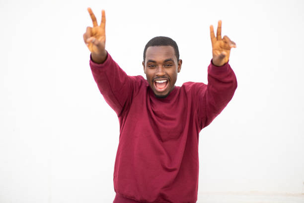 istock Excited young black guy showing peace sign with both hands 2200065739