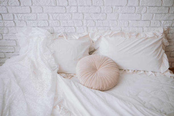 istock Soft bedding arrangement with decorative pillows in a cozy bedroom setting 2200065881