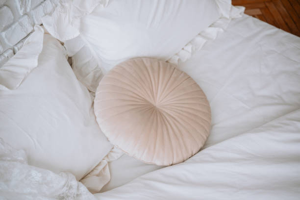 istock Soft round pillow rests on a neatly made bed in cozy bedroom setting 2200065887