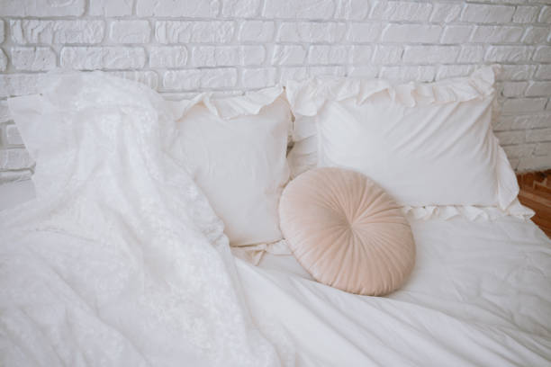 istock Elegant wedding dress draped on a cozy white bed with decorative pillows 2200065890