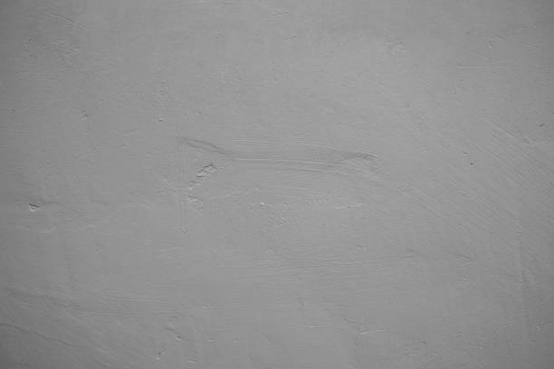 A smooth gray wall displays subtle variations in texture and tone.