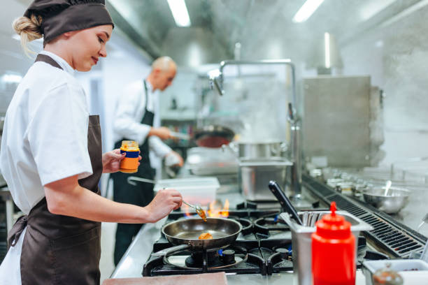 istock Professional chef adding sauce to a dish in a commercial kitchen 2200065957