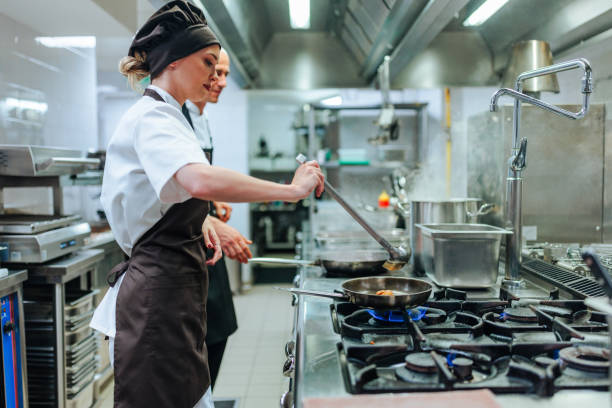 istock Chefs cooking in a professional kitchen using a gas stove 2200065959