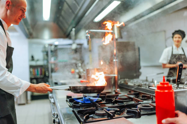 istock Professional chef cooking with fire in a pan in a restaurant kitchen 2200065962