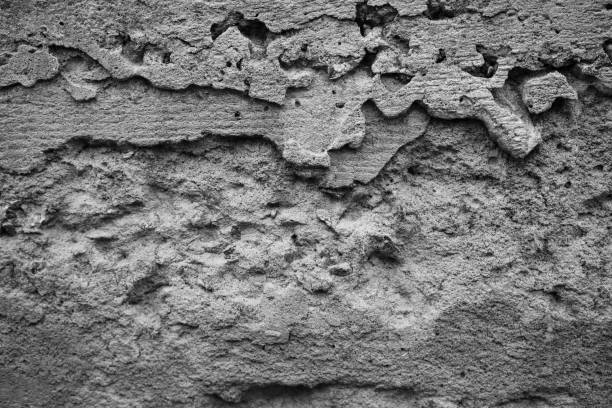 Textured gray wall with peeling layers enhances urban aesthetic charm