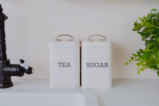 istock Kitchen countertop with tea and sugar containers beside a faucet 2200066092