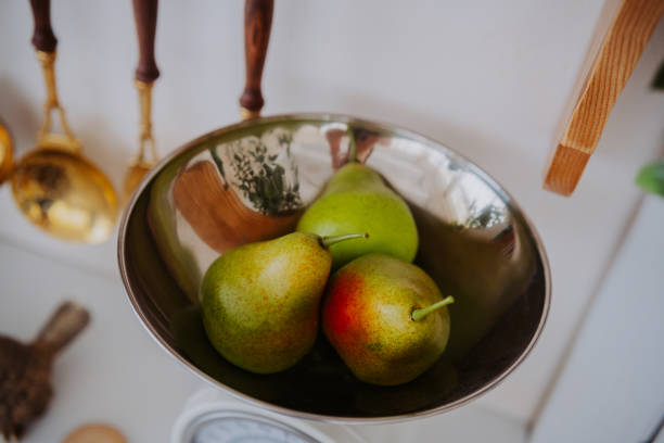 istock Fresh pears on a scale in a kitchen with copper utensils nearby 2200066103