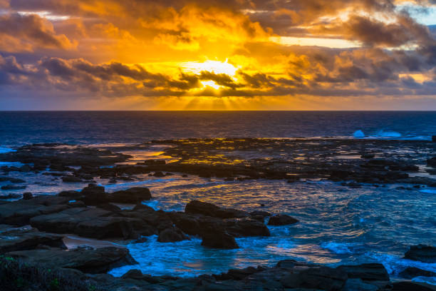 A windy Sunrise over the sea from Soldiers Beach at Norah Head, NSW, Australia.