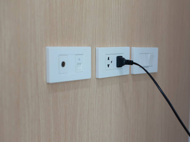 istock The wooden wall electrical outlet is being plugged in. 2200074437