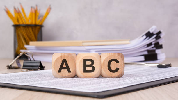 istock wooden blocks spelling ABC on office documents, symbolizing learning, basics, and business concepts 2200080223