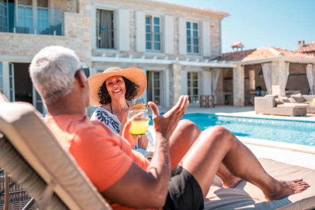 istock Senior Hispanic Man and Woman Lounging in Deckchairs with Refreshing Drinks 2200082279