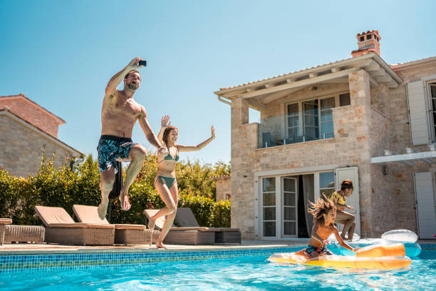 istock Caucasian Dad and Mixed Race Kids Splash and Jump 2200082340