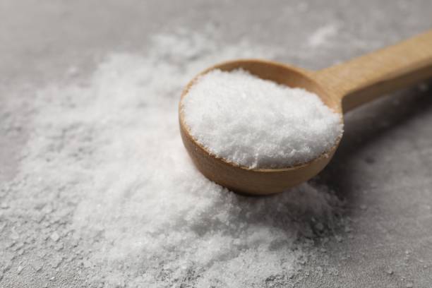 istock Natural salt and wooden spoon on grey table, closeup 2200085051