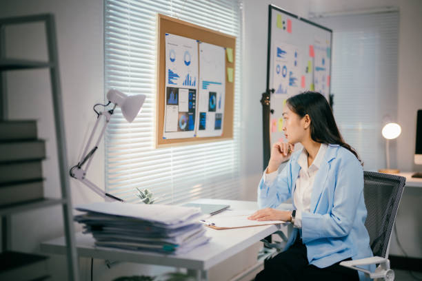 istock Professional Asian businesswoman reviewing data visualization, strategizing startup growth in contemporary workplace environment 2200085468