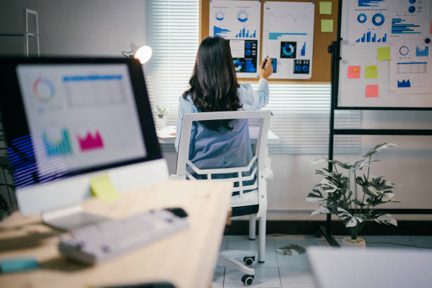 istock Professional businesswoman analyzing market data, sitting at workspace with charts and graphs, concentrating on strategic business planning and performance metrics 2200085501
