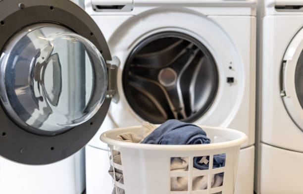 istock Laundry basket in front of a washing machine at the laundromat 2200085546