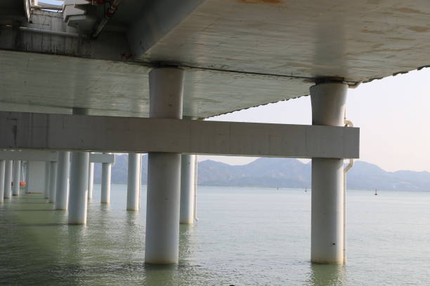 A bridge pier with a view of the water. The water is calm and the bridge is empty