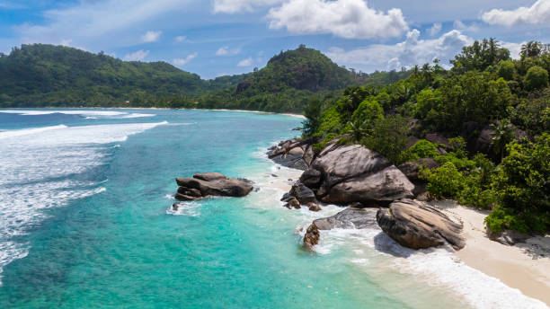 istock White sandy beach with turquoise waves and rocks. Seychelles, Mahe. 2200097415