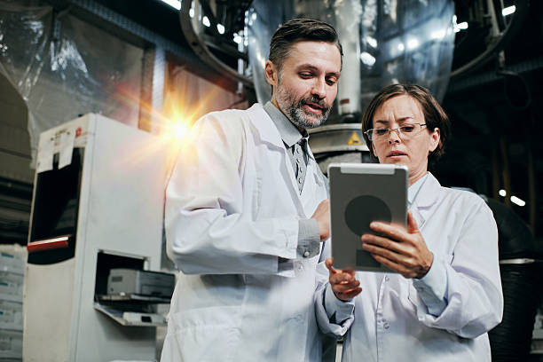 istock Two engineers working at the factory warehouse, discussing data on tablet screen 2200097648