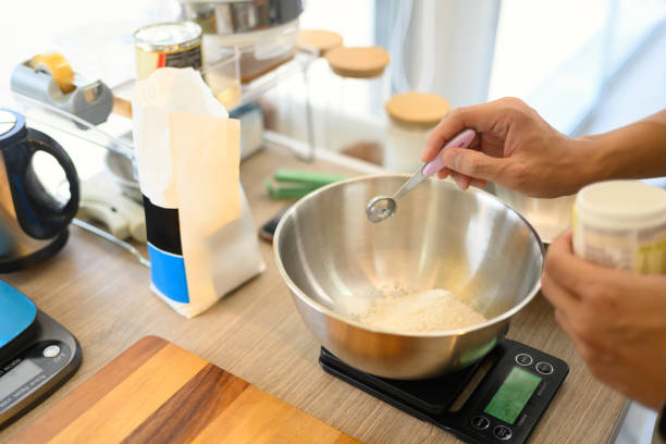 istock Close up of baker measuring ingredients with a teaspoon for cookie dough 2200098085