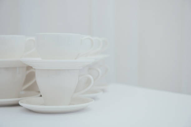 Close up view of white coffee mug columns stacked side by side in four rows