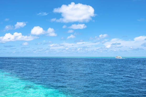 Tropical ocean and turquoise lagoon with sunny blue sky background