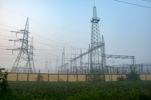 High voltage electricity transmission tower, also known as an electricity pylon, standing tall against a clear sky, representing power infrastructure and energy distribution.