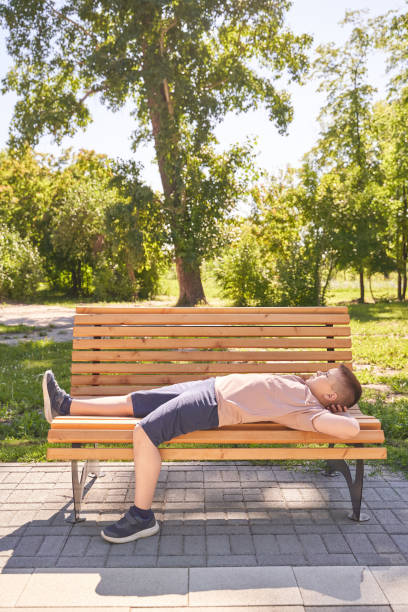 istock Child relaxing on park bench under sunny sky in peaceful summer landscape 2200108780